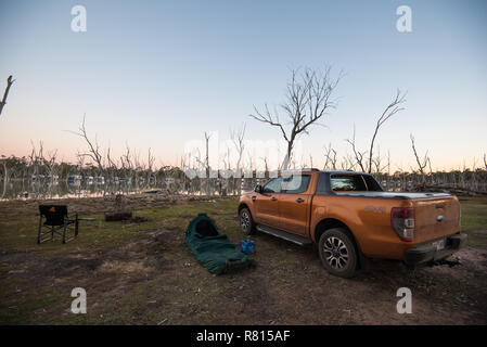 Ford Ranger 4WD a waterfront campeggio a Lara Zone Umide vicino Barcaldine, Queensland con swag e camp sedia. Foto Stock