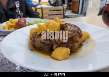 Rabo de toro, coda di vitellone stufato di carne con patate su una piastra bianca nella terrazza all'aperto, ristorante, tapas, Cordoba, Spagna. Foto Stock