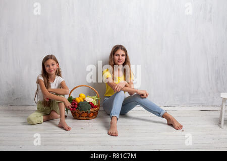 Bellissima ragazza con una cesta di verdure fresche, ravanelli, broccoli, pomodoro pepe Foto Stock