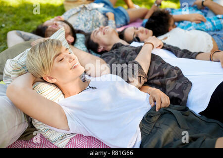 Happy amici agghiaccianti sulla coperta picnic in estate Foto Stock