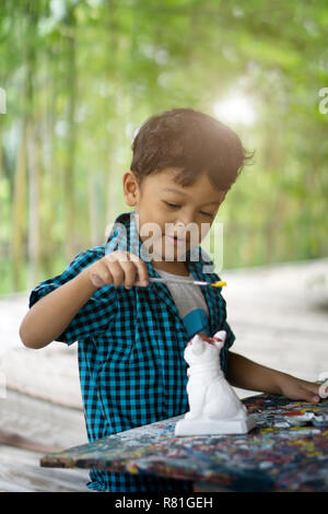 Ragazzi asiatici godendo la sua pittura con pennello. Foto Stock