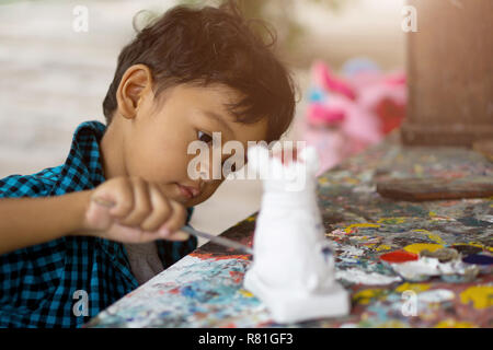 Ragazzi asiatici godendo la sua pittura con pennello. Foto Stock