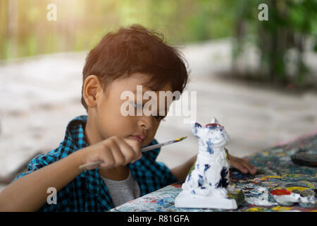 Ragazzi asiatici godendo la sua pittura con pennello. Foto Stock