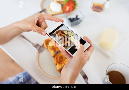 Le mani con gli smartphone a fotografare il cibo Foto Stock