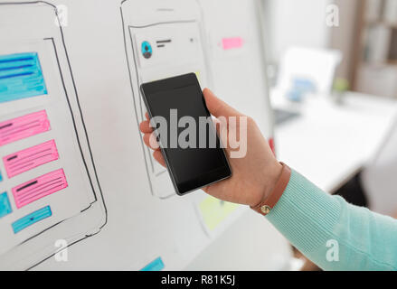 Designer di interfaccia utente o sviluppatore mano azienda smartphone Foto Stock