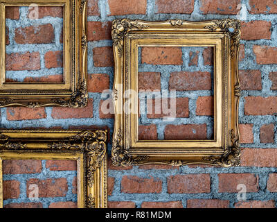 Tre Vecchi vuoti ornati cornici dorate appesa sul muro di mattoni. Foto Stock