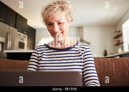 Senior white woman using laptop computer at home, close up Foto Stock