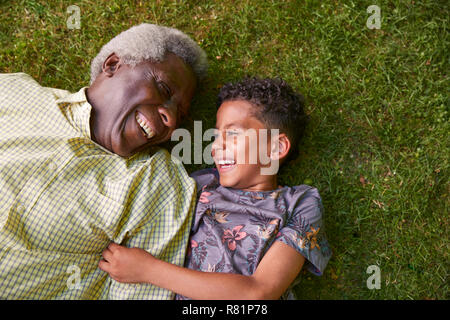 Ragazzo e suo nonno giacente su erba, overhead vicino fino Foto Stock