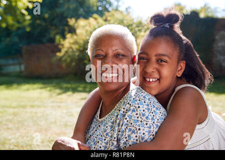 Senior donna nera e la nipote sit abbracciando al di fuori Foto Stock