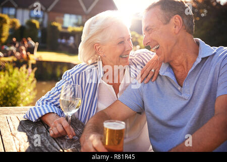 Coppia senior seduta a tavola gustando dehor estivo drink al Pub Foto Stock