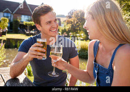 Coppia seduta a tavola gustando dehor estivo drink al Pub Foto Stock