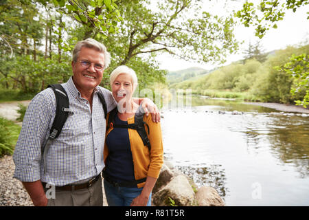 Ritratto di coppia Senior Escursionismo lungo il percorso dal fiume in UK Lake District Foto Stock