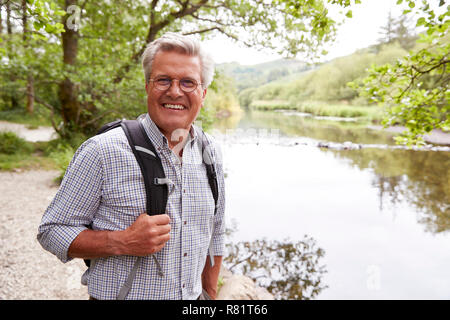 Ritratto di uomo Senior Escursionismo lungo il percorso dal fiume in UK Lake District Foto Stock