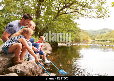 Famiglia la pesca con le reti nel fiume in UK Lake District Foto Stock