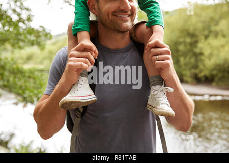 Chiusura del padre figlio che porta sulle spalle sulla Passeggiata a Fiume Foto Stock