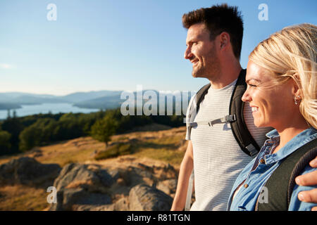 Matura in piedi alla cima della collina su escursione attraverso la campagna nel Lake District UK Foto Stock