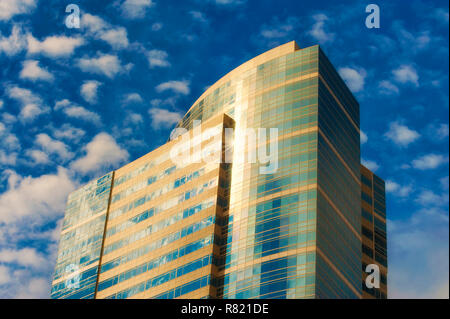 Portland, Oregon, Stati Uniti d'America - 8 Ottobre 2016: Nuvoloso cieli blu e riflettono la luce del sole fuori un edificio alto a Portland, Oregon. Foto Stock