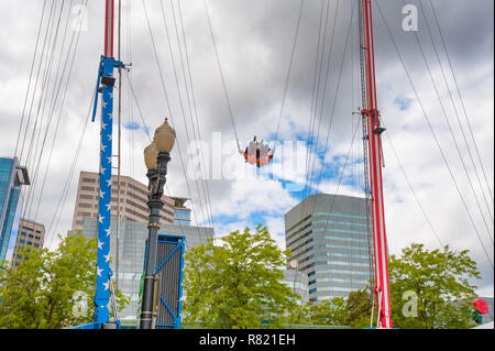 Portland, Oregon, Stati Uniti d'America - 29 Maggio 2010: Un bungie come il carnevale ride spara piloti alta nel cielo nuvoloso lungo Tom McCall acqua Parco anteriore. Foto Stock