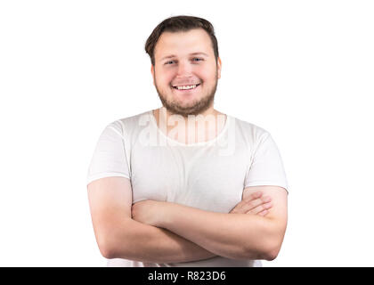 Ritratto di giovane paffuto uomo in bianco t-shirt tenendo le braccia incrociate e sorridente alla fotocamera su sfondo bianco Foto Stock