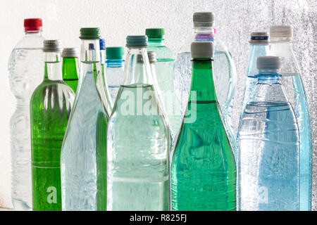 Diverse varietà di acqua minerale in bottiglie di vetro e di plastica o di PET Foto Stock