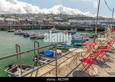 La città costiera di Porthleven in Cornovaglia, Inghilterra, mostrando piccole barche nel porto e gli edifici circostanti. Foto Stock