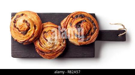 Appena sfornato ciambelle dolci sulla lavagna nera isolati su sfondo bianco, vista dall'alto Foto Stock