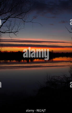 Croazia, parco naturale Lonjsko polje, bel rosso tramonto sul fiume Sava in autunno, la riflessione sull'acqua Foto Stock