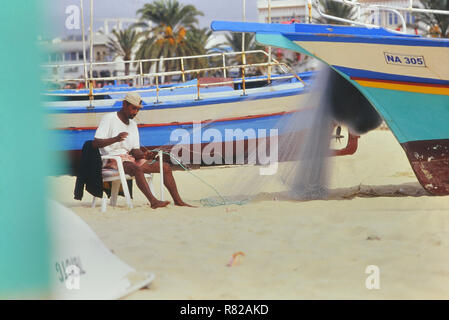 Pescatore locale riassettando le reti. Hammamet. La Tunisia. Il Nord Africa Foto Stock