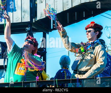 I festaioli buttare perle per la folla come loro il galleggiante si sposta lungo Canal Street in Mobile, Alabama, durante il Joe Caino parata del giorno a Mardi Gras. Foto Stock