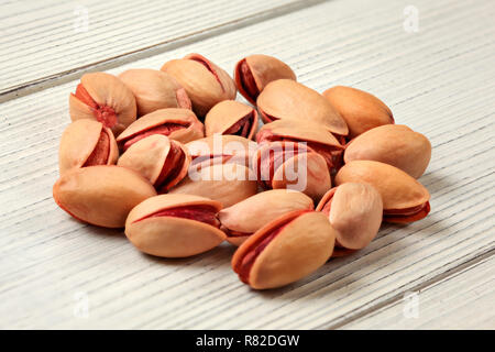 Clsoeup al piccolo mucchio di rosso turco pistacchi su lavagne bianche desk. Foto Stock