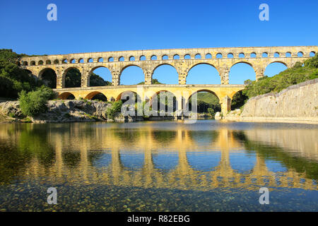 Acquedotto Pont du Gard riflessa nel fiume Gardon, Francia meridionale. Esso è il più alto di tutti i privilegi elevati acquedotti romani. Foto Stock