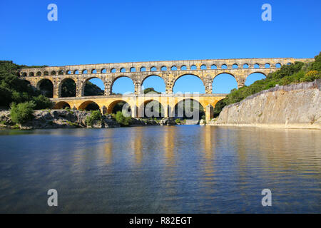 Acquedotto Pont du Gard riflessa nel fiume Gardon, Francia meridionale. Esso è il più alto di tutti i privilegi elevati acquedotti romani. Foto Stock