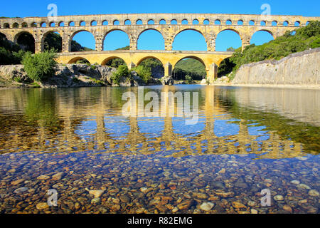 Acquedotto Pont du Gard riflessa nel fiume Gardon, Francia meridionale. Esso è il più alto di tutti i privilegi elevati acquedotti romani. Foto Stock