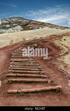 Paesaggio con parte del famoso sentiero escursionistico in Isola di Madeira, Portogallo. Scale realizzata del tutto naturale di vecchi tronchi di legno che giace sulla terra rossastra di uninh Foto Stock