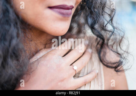 Close up della donna di bocca e la mano con un anello di fidanzamento Foto Stock