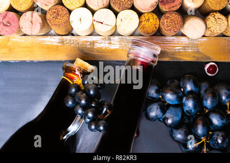 Aceto balsamico in una caraffa di vetro con uve fresche e il vino e i tappi di sughero, antiossidanti Foto Stock