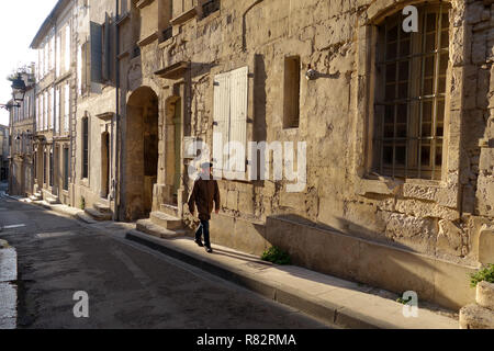 Serata di lunghe ombre proiettate da uomo francese indossando berry hat in Rue Des Arenes a Arles Francia Foto Stock