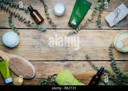 Eucalipto spa concept. Eucalipto, olio, cosmetici, accessori per il bagno, massaggi e relax. Spa sfondo su un tavolo di legno. Foto Stock