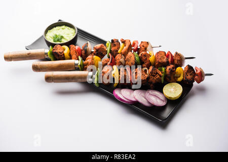 Pollo Tikka /Kebab sghemba. Tradizionale piatto indiano cucinati sul carbone e fiamma, condito & colorfully guarnita. servita con chutney di verde e insalata mista Foto Stock