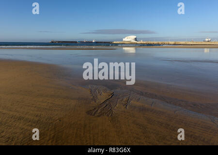 Matosinhos tranquilla spiaggia con la bassa marea su un mattino luminoso con interessanti strutture di sabbia in primo piano e il sud del porto di Leixoes in backgr Foto Stock