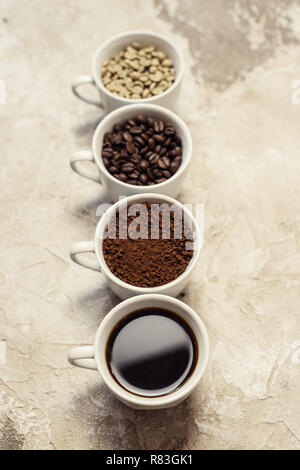 Quattro tipi di caffè non torrefatto, fagiolo, terra e uno in coppa Foto Stock