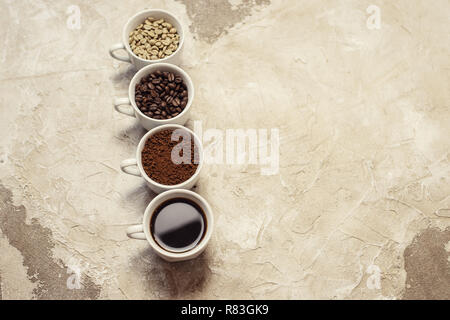 Quattro tipi di caffè non torrefatto, fagiolo, terra e uno in coppa Foto Stock