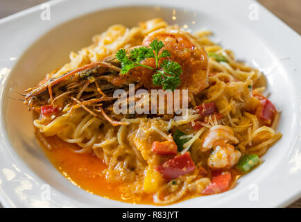 Spaghetti con gamberi tigre saltato con olio di gamberi in una piastra Foto Stock