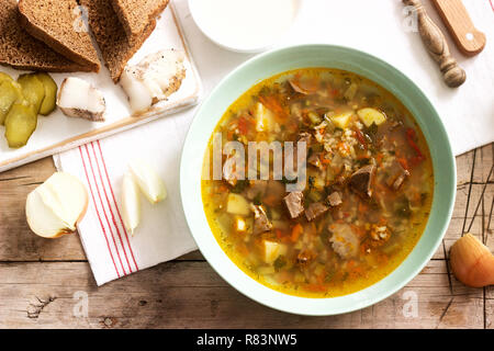 Rassolnik, tradizionale zuppa di Russo, servito con vari snack e la vodka. Stile rustico. Foto Stock