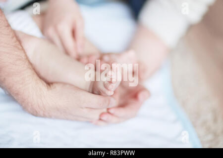 Bambini I piedi nelle mani dei genitori Foto Stock