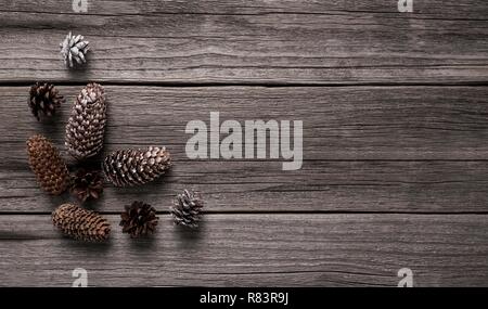 I coni sono sparsi su vecchie tavole di legno. Foto Stock