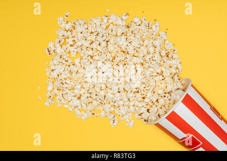 Vista superiore della ribaltata benna a strisce con popcorn isolato su giallo Foto Stock