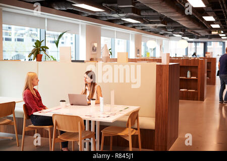 Due giovani imprenditrici avente intervista informale nella zona caffetteria all assunzione di laureati giorno di valutazione Foto Stock