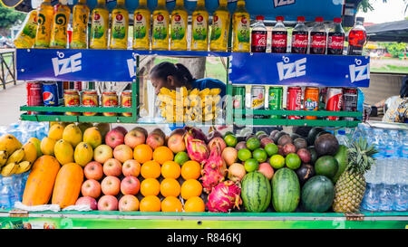 SIEM REAP, Cambogia - Novembre 24, 2017: donna asiatica - venditore con varietà di frutta tra cui dragon frutta, litchi e carote, esposte per la vendita Foto Stock