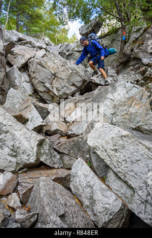 Escursionista la scalata di crack, La Cloche Silhouette Trail, Killarney Provincial Park, Ontario, Canada Foto Stock